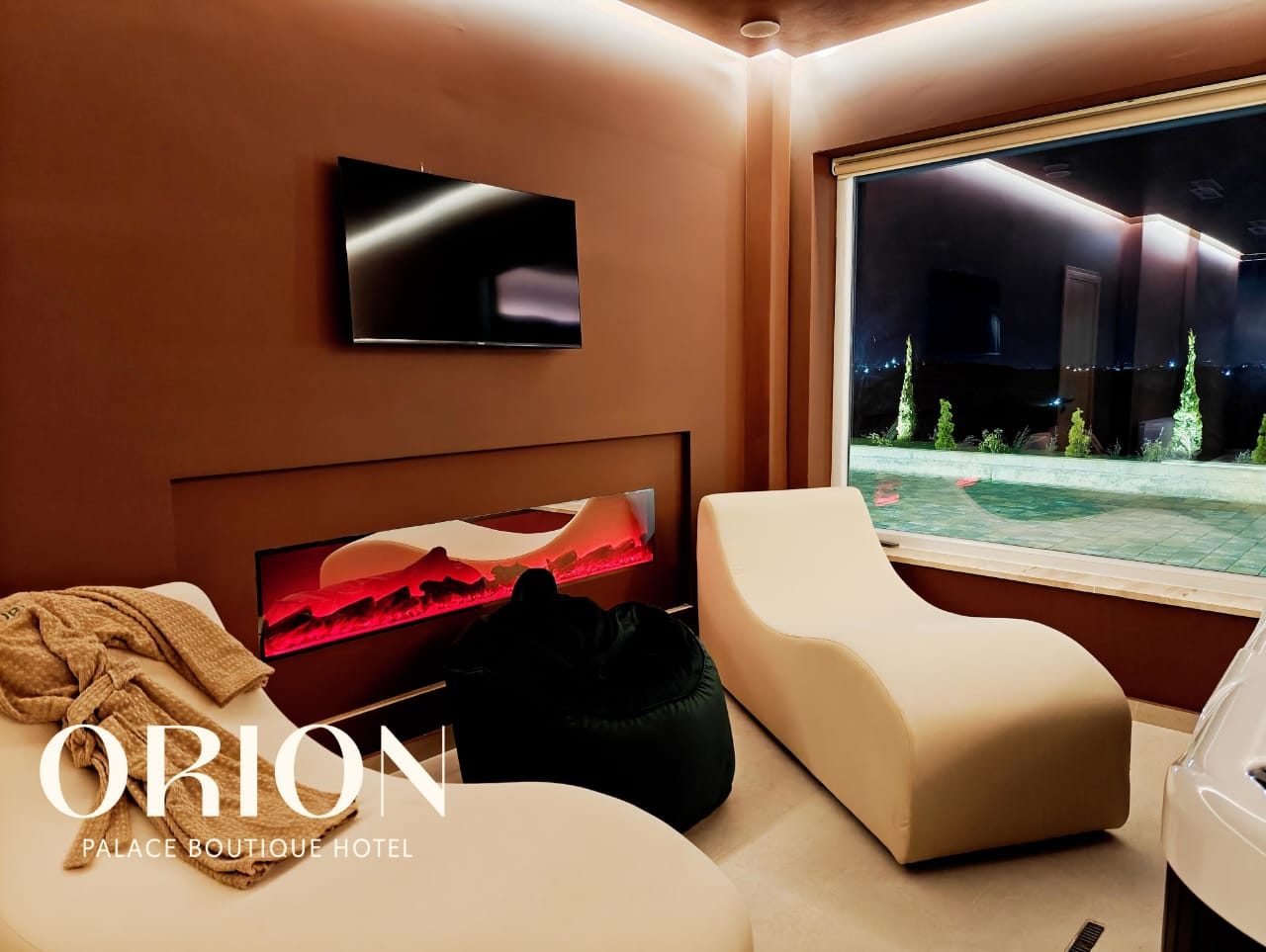 Orion Spa — wellness room con camino e vista piscina